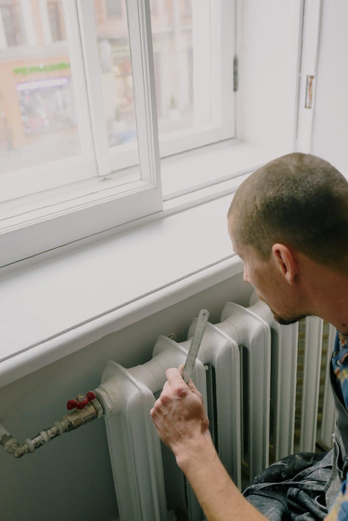 The Art of Drawing Readers In: Your attractive post title goes here From above side view of crop anonymous male worker with ruler near radiator and windowsill in house